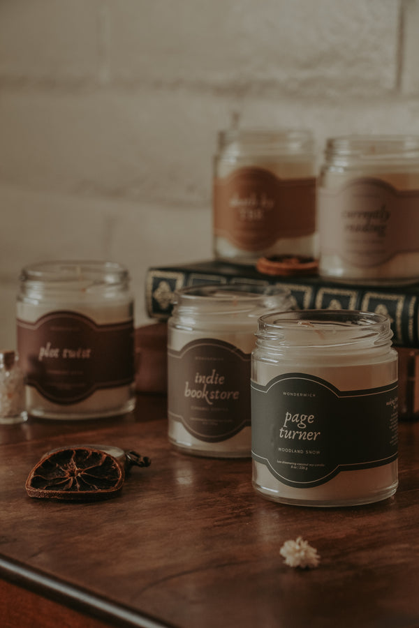 Wonderwick bookish candle collection styled on a table with an antique book
