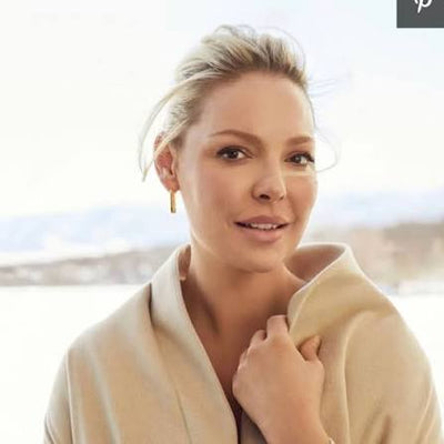 Katherine Heigl in a cream wool coat by a bright window