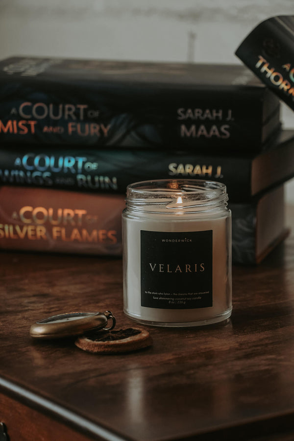 Wonderwick Velaris candle in front of a stack of Sarah J. Maas A Court of Thorns and Roses books
